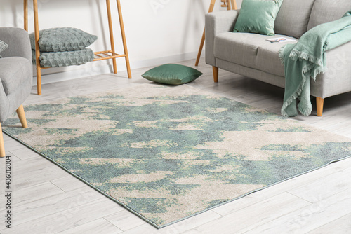 Fotografie Soft stylish carpet on grey wooden floor in living room interior