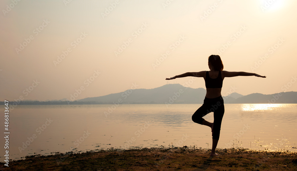 Yoga silhouette. Meditation woman on the ocean during amazing sunset. Fitness and healthy lifestyle.