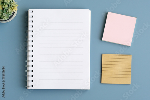 Blank notebook paper on blue table background, top view, flat lay