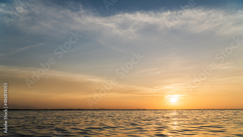 Sunset sky over sea in the evening with orange sunlight