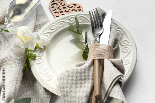 Beautiful table setting for wedding and flowers on light background