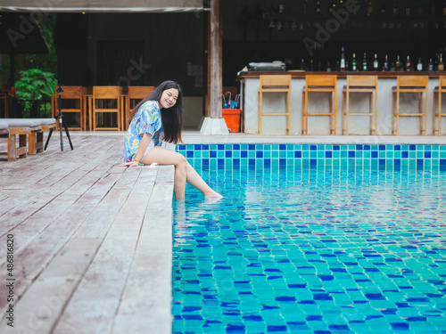 Young asian woman relaxing outdoor beside swimming pool in hotel resort for leisure vacation © TongTa