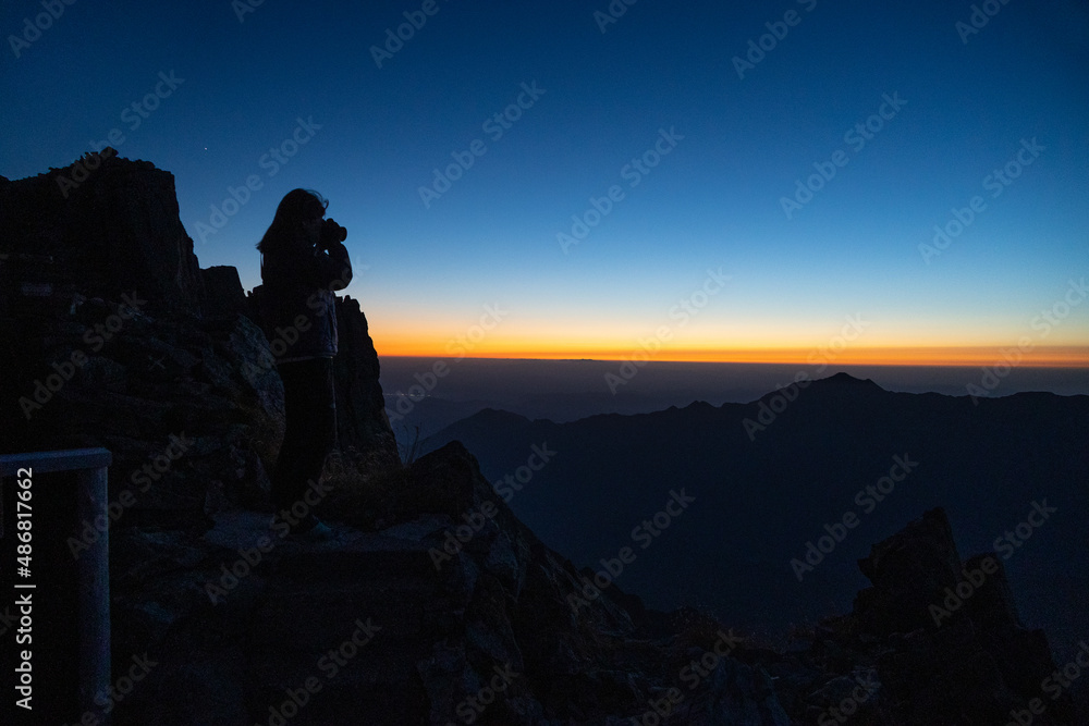 夕日を納める登山家