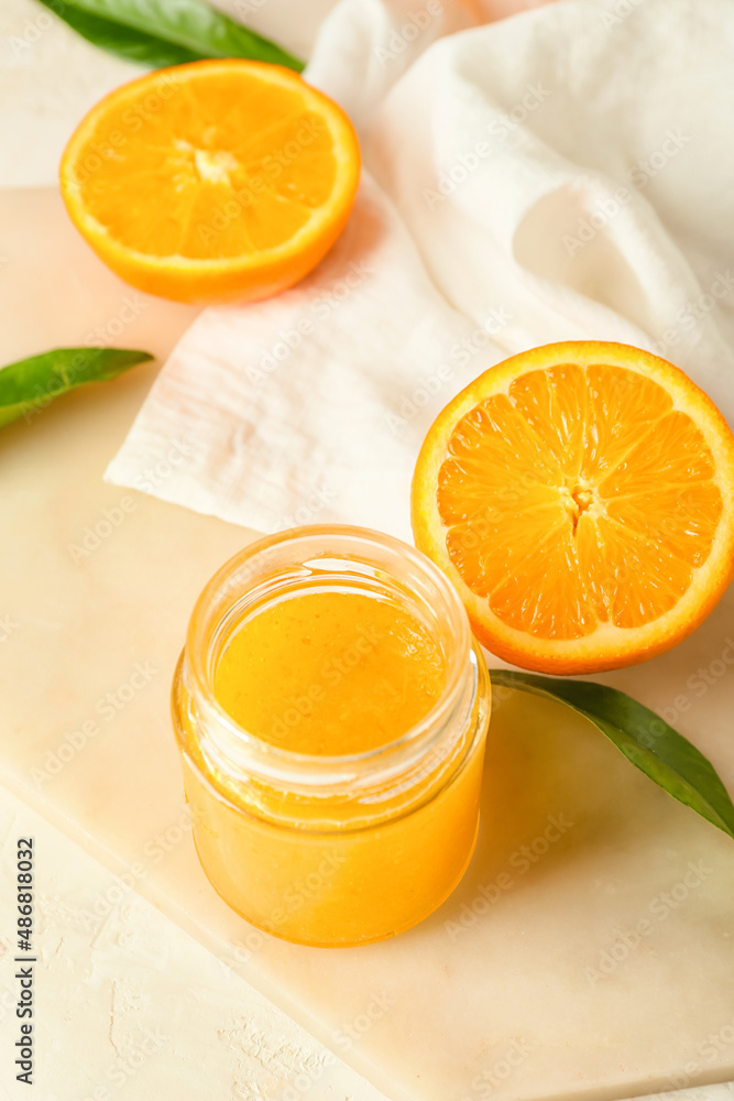 Glass jar of tasty orange jam on table, closeup Glass jar of tasty orange jam on table, closeup