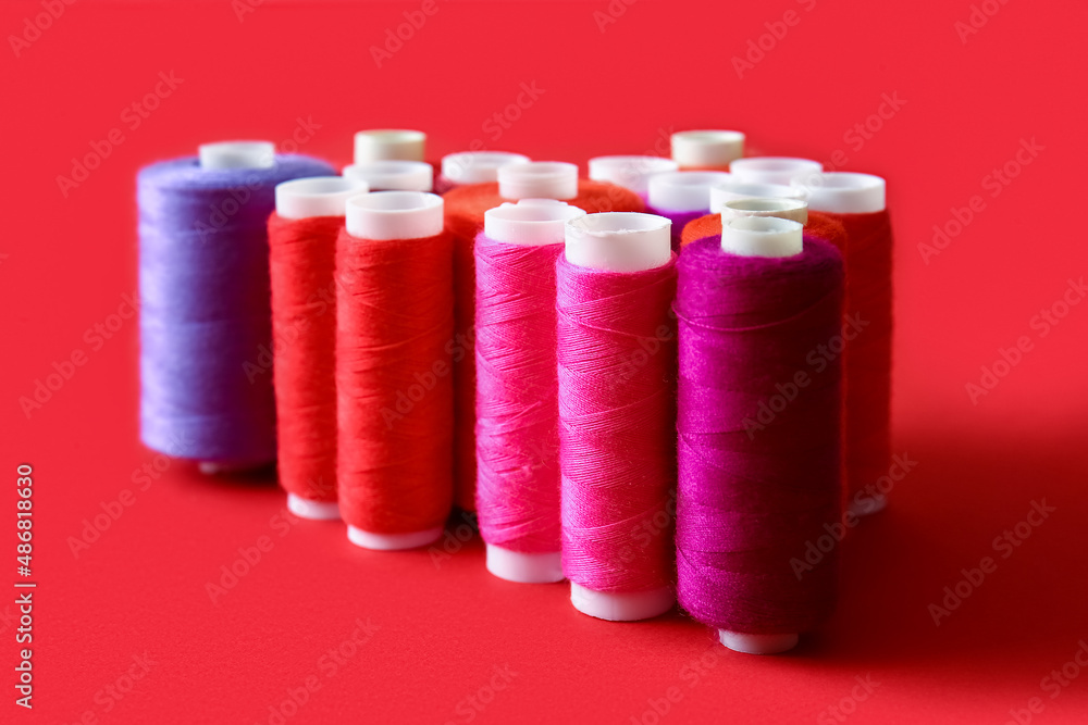 Thread spools on red background, closeup Thread spools on red background, closeup