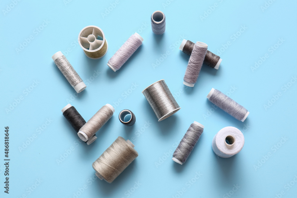 Fototapeta premium Thread spools on blue background