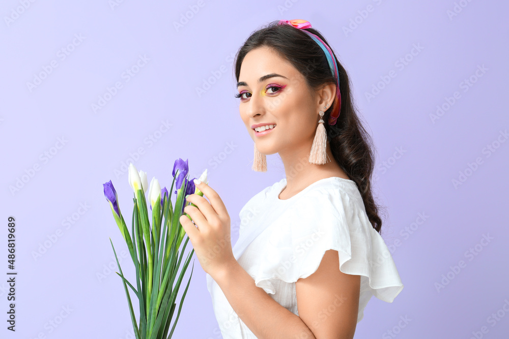 Young woman with creative makeup and bouquet of iris flowers on violet background. International Women's Day Young woman with creative makeup and bouquet of iris flowers on violet background. International Women's Day
