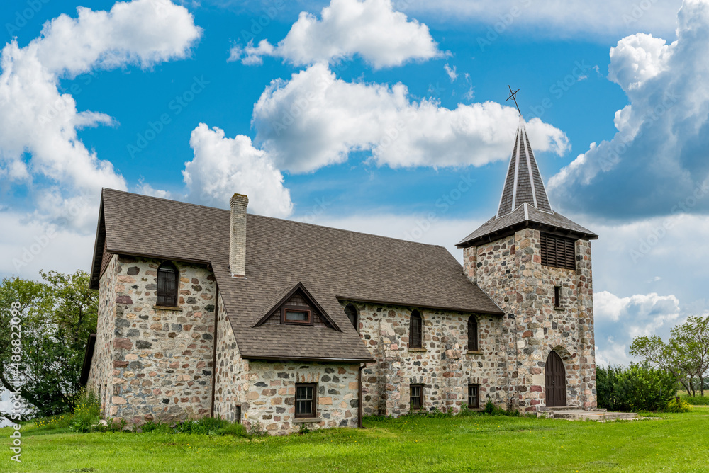 Blue sky over St. Andrews Anglican stone church in Heward, SK