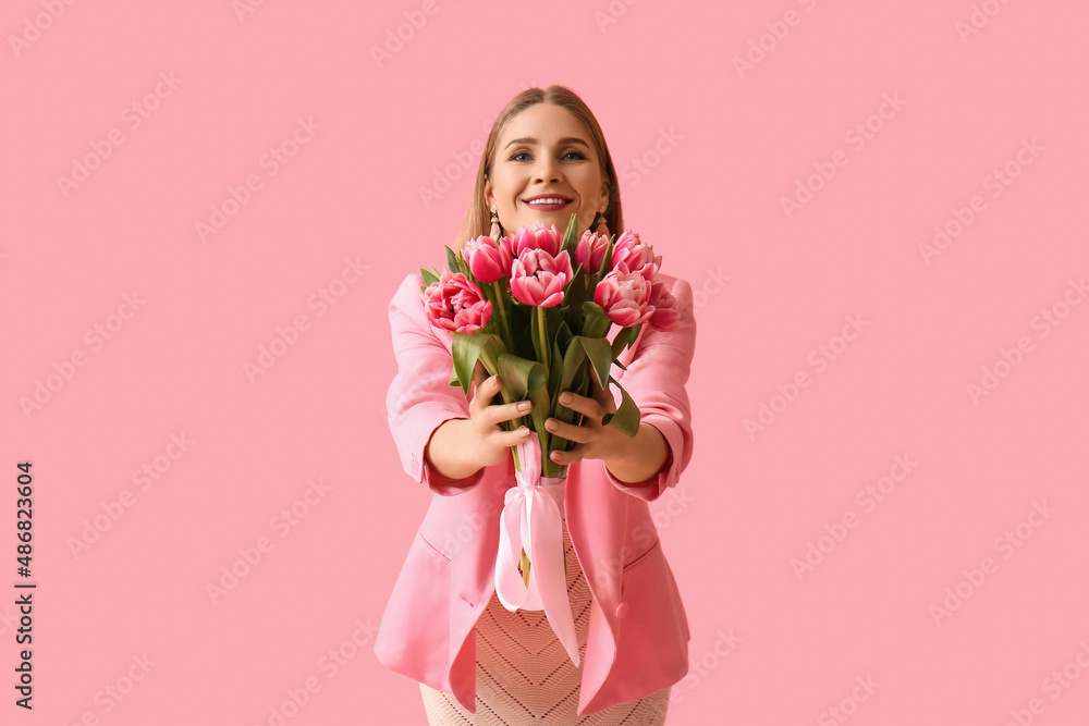 Beautiful woman with bouquet of tulips on pink background. International Women's Day Beautiful woman with bouquet of tulips on pink background. International Women's Day