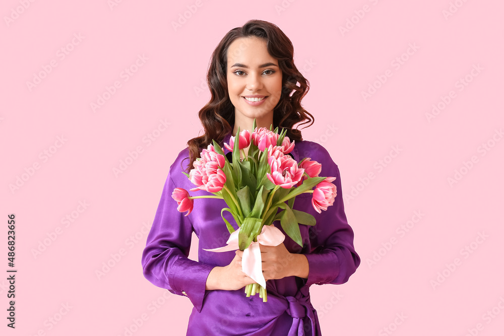 Smiling young woman with bouquet of tulips on pink background. International Women's Day Smiling young woman with bouquet of tulips on pink background. International Women's Day