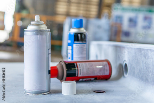 Cans of spray Penetrant Testing on on material steel and blur factory in background photo