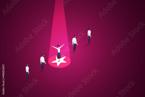 Businesswoman standing in a striking light unlike other employees.