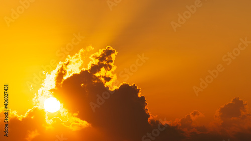 orange sky with sun shining behind clouds at morning, nature background