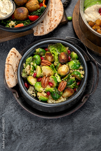 Brussel sprout salad with bulgur on dark background.