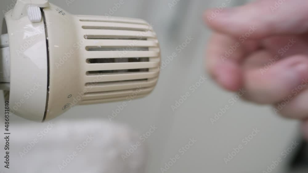 Setting Low the Radiator Temperature, Changing Thermostat Value, and Checking Thermic Energy Consumption. Energy Crisis Concept. Setting Low the Radiator Temperature, Changing Thermostat Value, and Checking Thermic Energy Consumption. Energy Crisis Concept.