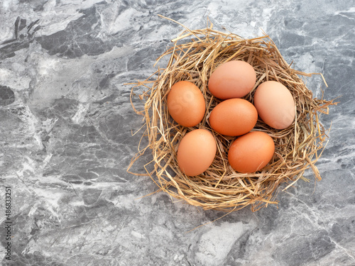 Eggs in a bird's nest on a black and gray marble background for Easter.