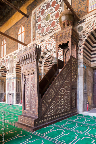 Colorful decorated marble wall with wooden Minbar, aka Platform, at Mamluk era public historical mosque of Sultan al Muayyad, Old Cairo, Egypt photo