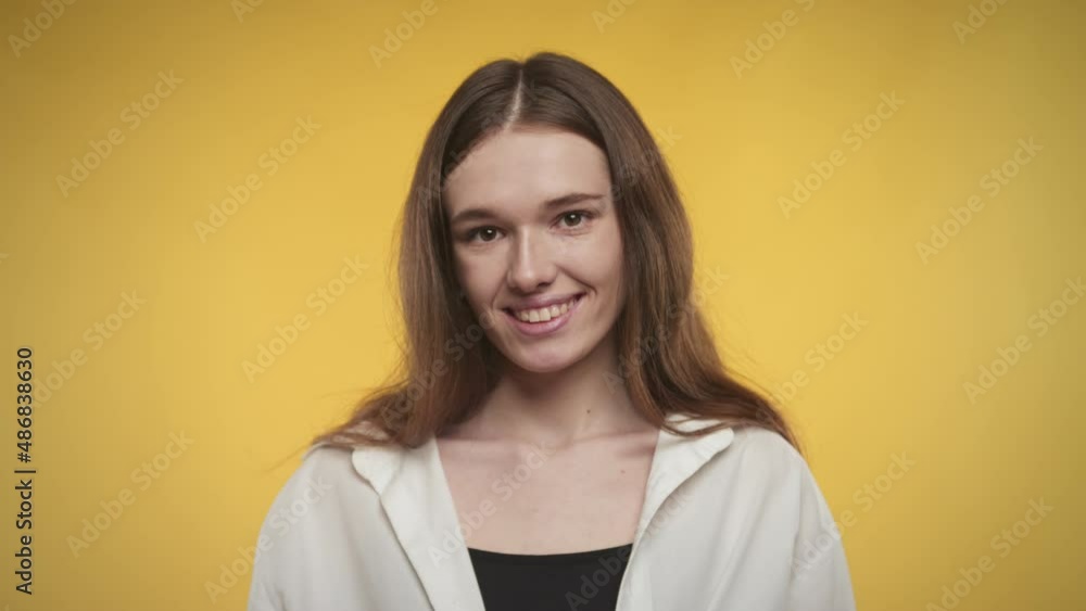 Young adult caucasian woman is laughing on a bright yellow background Young adult caucasian woman is laughing on a bright yellow background