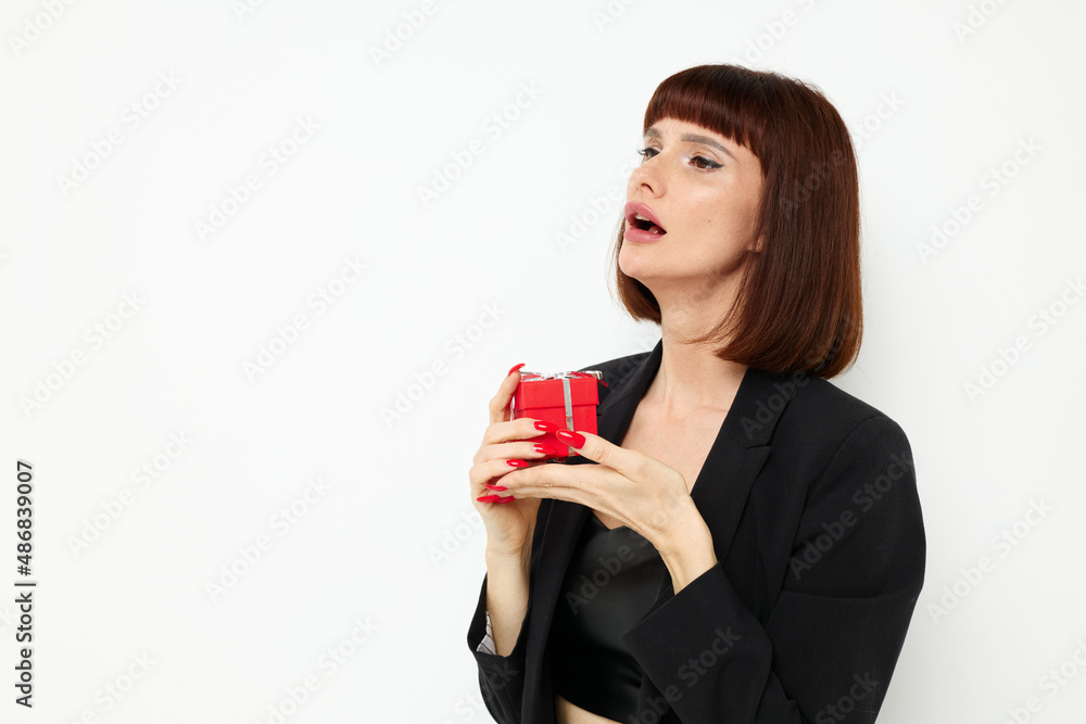 portrait of a woman with gift small box in a leather suit black jacket isolated background portrait of a woman with gift small box in a leather suit black jacket isolated background