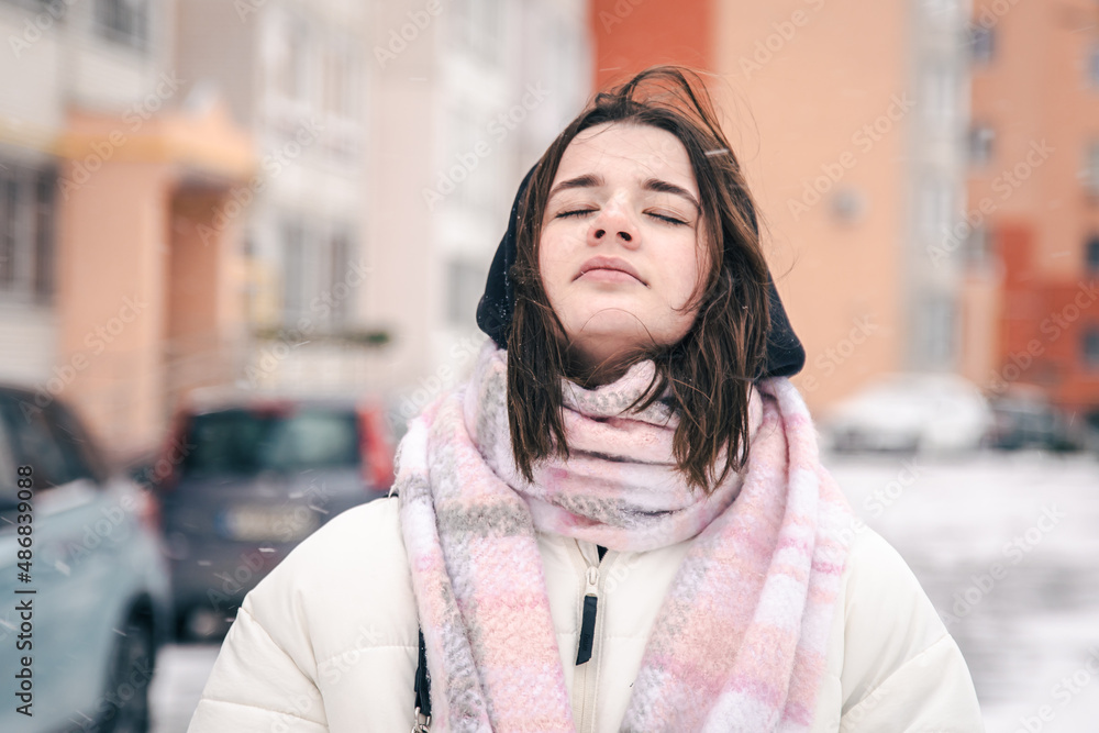 Portrait of a stylish young woman in winter outside, blurred background. Portrait of a stylish young woman in winter outside, blurred background.