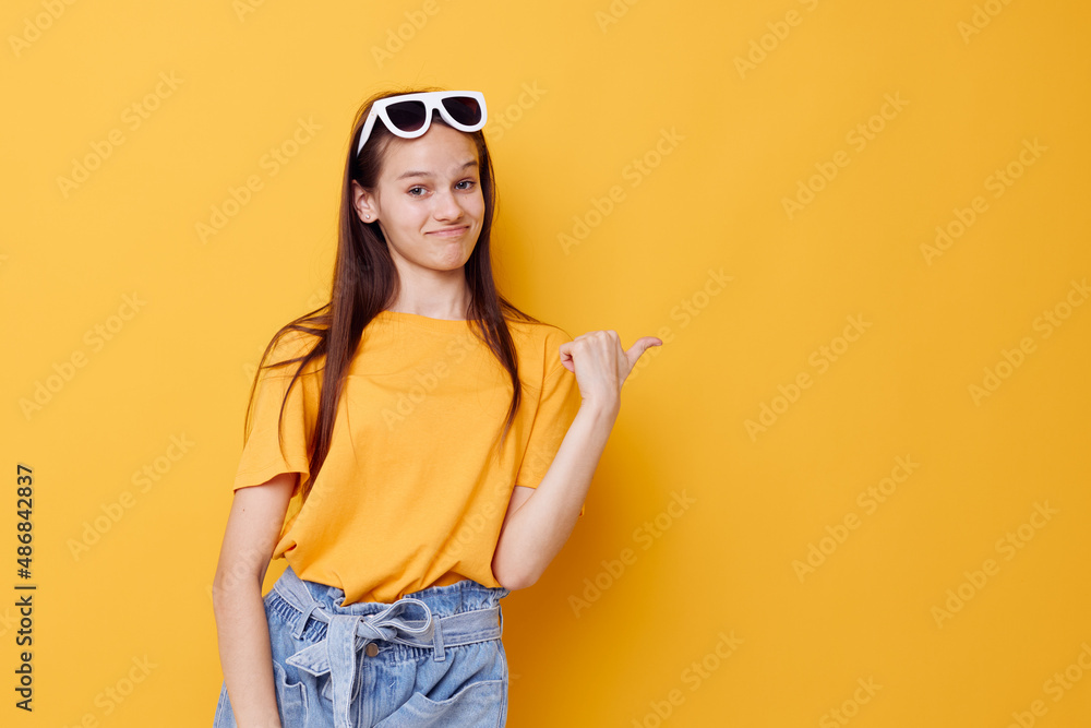 Fototapeta premium young beautiful woman fashion in yellow t-shirt denim shorts yellow background