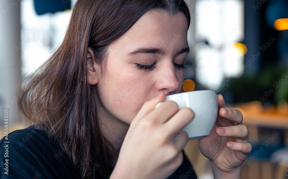 Portrait of a young woman with a cup of tea in a cafe. Portrait of a young woman with a cup of tea in a cafe.