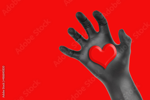 Wallpaper Mural Heart in a black gloved hand isolated on red Torontodigital.ca