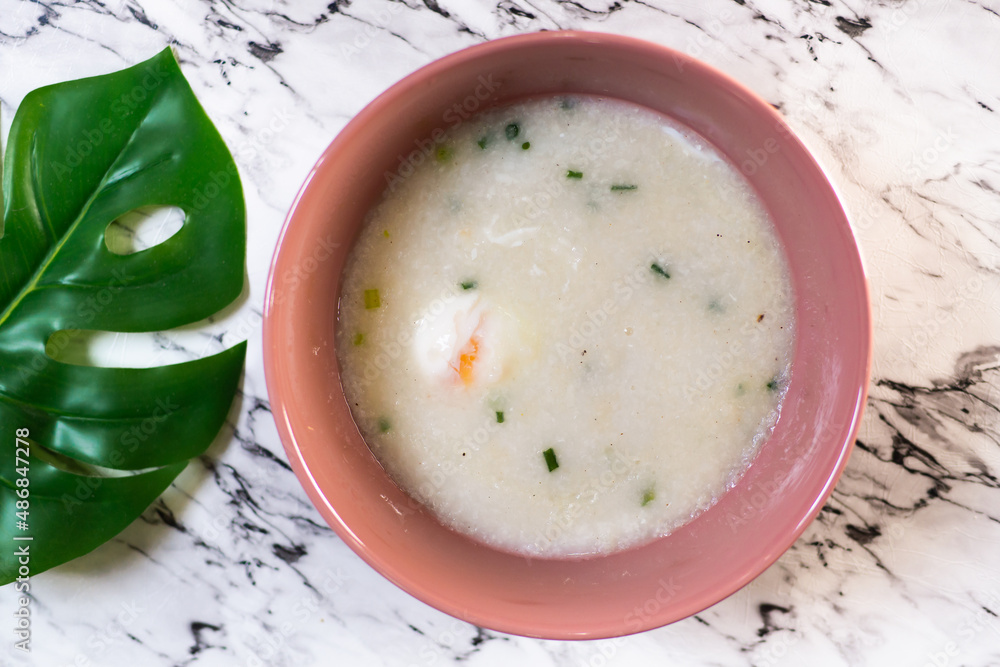 Top view of vegetarian rice porridge bowl on marble background with leaf decoration. Top view of vegetarian rice porridge bowl on marble background with leaf decoration.