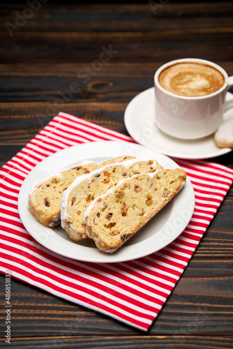 Slices of Traditional Christmas stollen cake with marzipan and dried fruit and cup of coffee