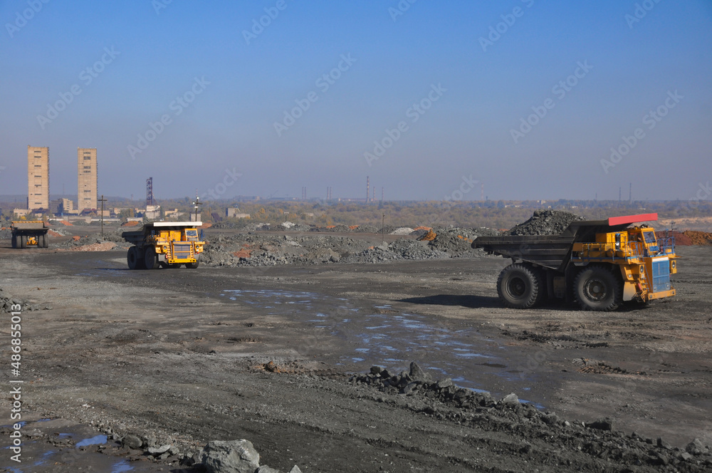 Mining dump truck transports rock, iron ore along the side of the quarry. Mining dump truck transports rock, iron ore along the side of the quarry.