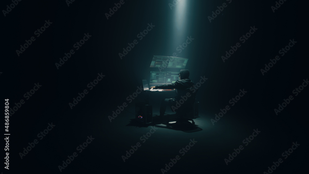 Minimalistic concept shot of male hacker using computer to access private data while sitting under spotlight in darkness