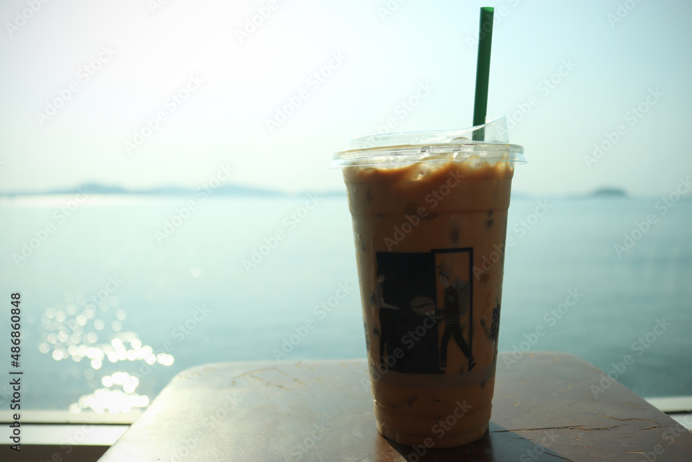 Φωτογραφία Iced coffee glass is placed on the table by the window of the sea background