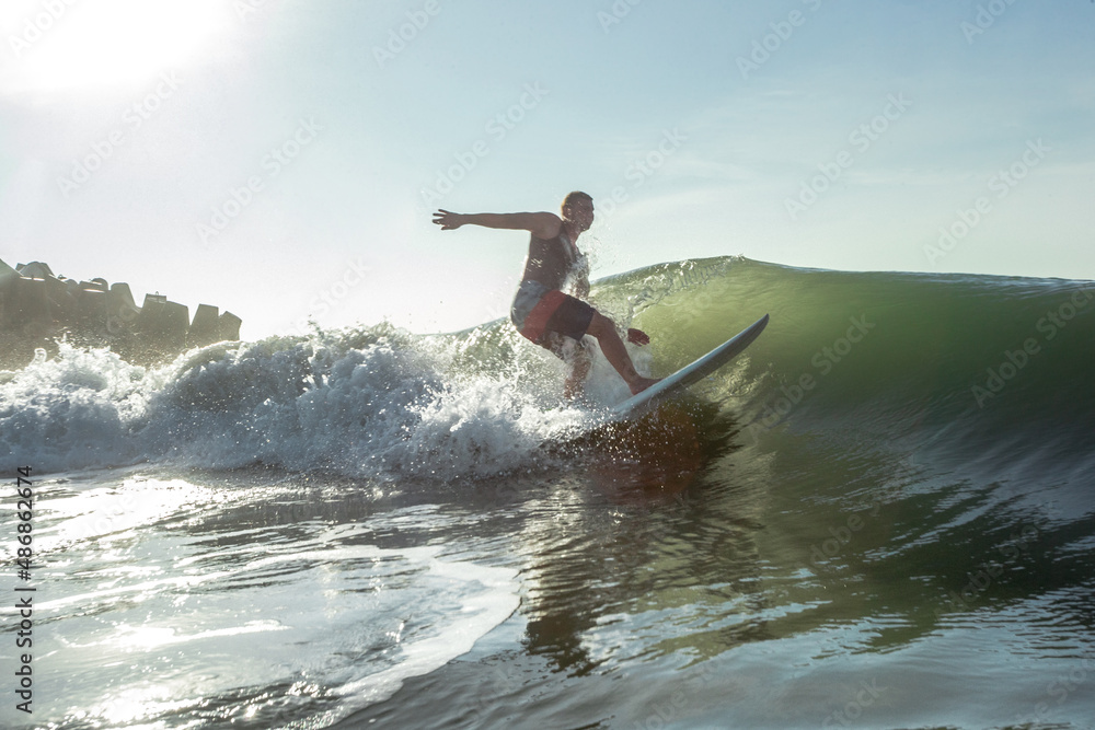 Young surfer with rides the tropical wave.