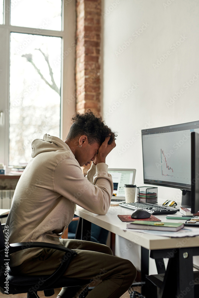 Frustrated stressed african american trader after stocks market chart going down