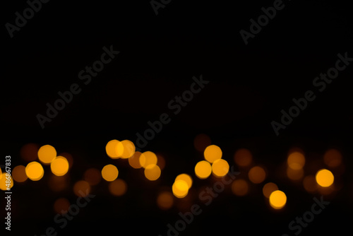 Golden glitter bokeh lights on black background, unfocused. Party, event, Festive, birthday background