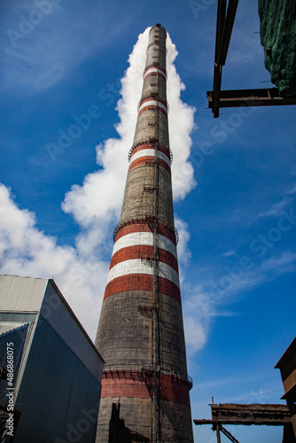 GRES-1 thermal power plant roof. Tall smoke stack with white smoke cloud. Metal element right top and down. Blue sky. Ekibastuz, Pavlodar region, Kazakhstan. photo