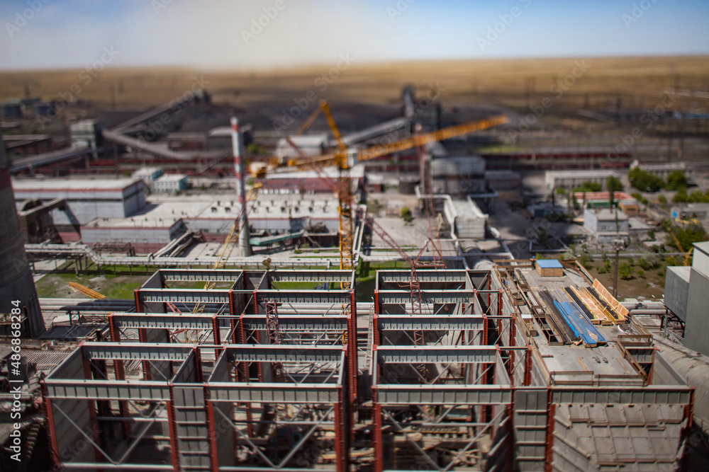 GRES-1 steam power station. Panoramic aerial view of coal bunkers structure.Renovation of electricity plant.Tilt-shifted and partially blurred photo.Blur on crane and landscape. Ekibastuz,Kazakhstan.