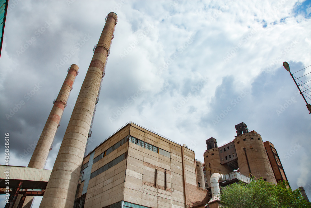 Foto Old outdated Soviet cement plant smoking stack and industrial building