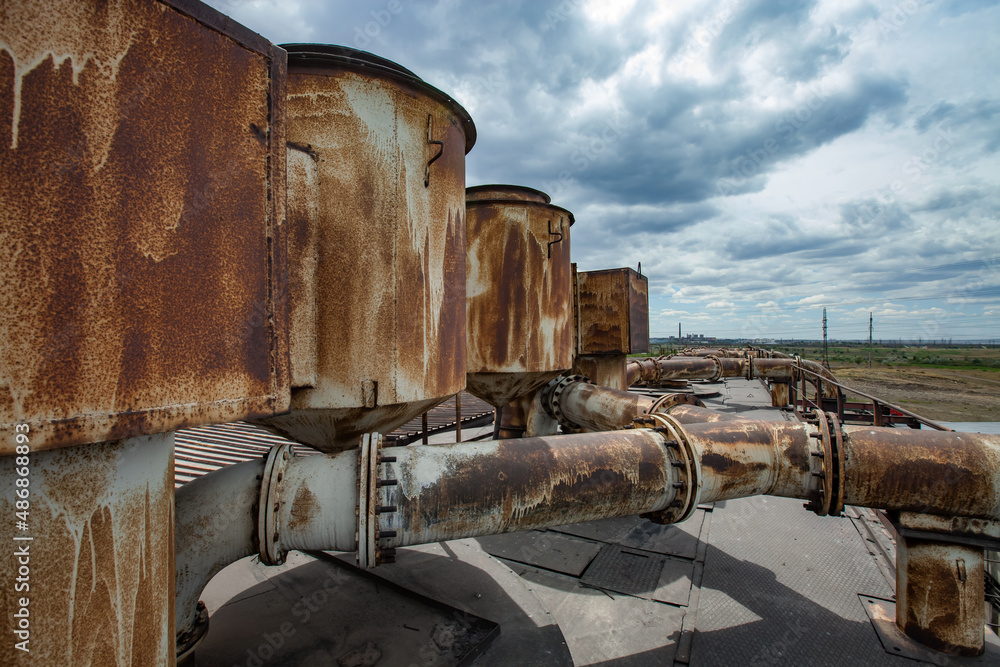 On the roof of heat electric plant. Old rusted textured pipes of ventilation system. Blue sky with clouds. Karaganda, Kazakhstan.
