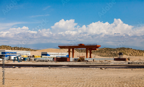 Altynkol, Kazakhstan - June 05, 2012: Railway station Altynkol. Construction of train container-loading terminal. Red gantry crane and railroad.