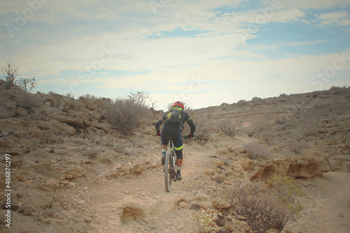 Mountain biker cycling a single track over rocky terrain (Tenerife, Spain)
