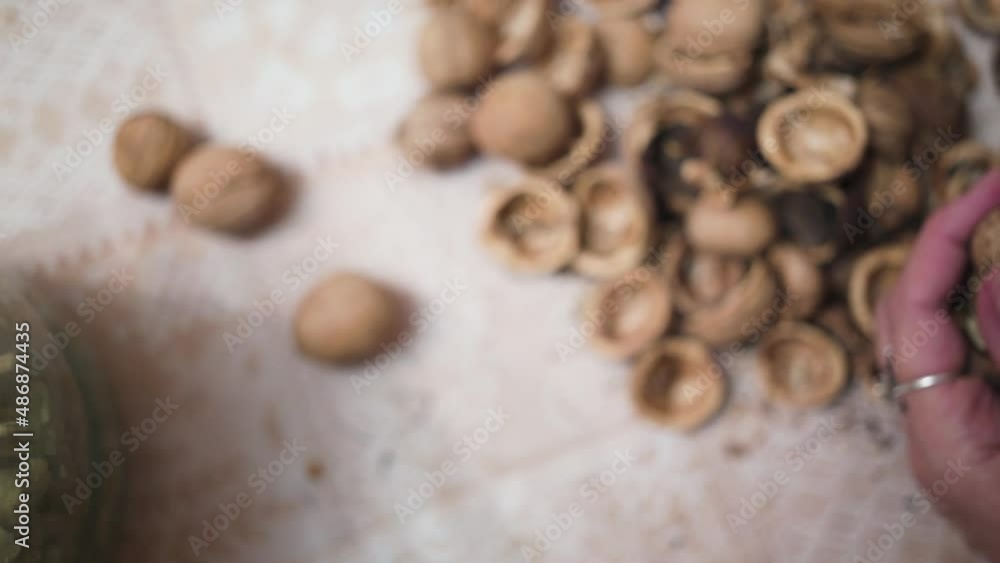 Walnuts in a glass jar, close-up of female hands Walnuts in a glass jar, close-up of female hands