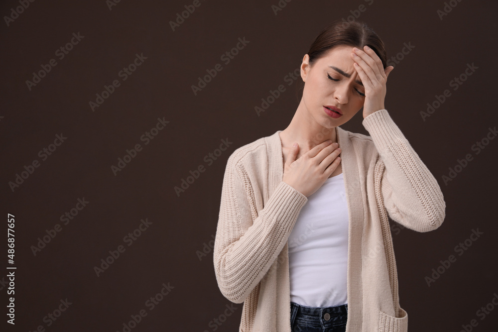 Woman suffering from headache on brown background, space for text. Cold symptoms Woman suffering from headache on brown background, space for text. Cold symptoms