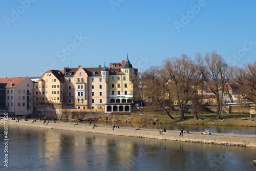 Regensburg, Germany - February, 25th 2021: People enjoying spring by the river Danube in Regensburg city center. High quality photo
