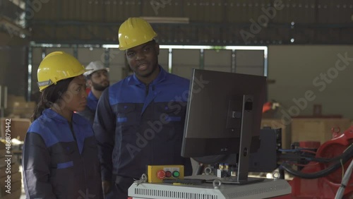 Team of Robotics engineer Look at computer about research and analysis automation robot arms machine in factory industrial for Production Line using system software support operator Industrial.