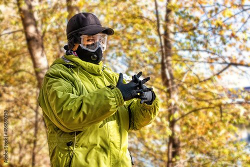 A woman wearing respirator mask walking in the forest protecting from COVID-19.