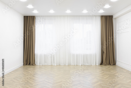 Empty room with white walls, large window and wooden floor © New Africa