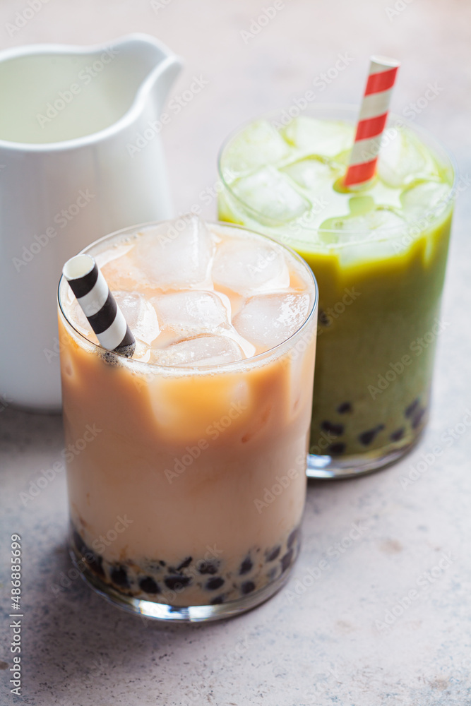 Milk bubble tea and matcha with tapioca pearls in glasses.
