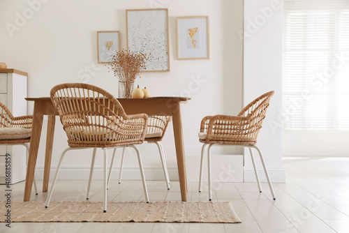 Dining room interior with wooden table and wicker chairs