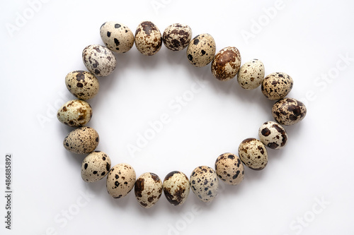 quail eggs are stacked in one large egg on a white background. Top view
